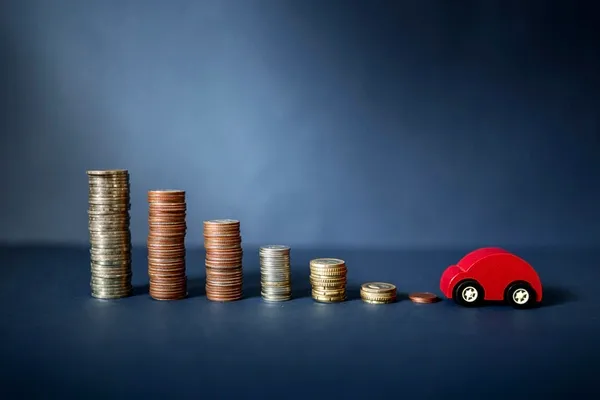 Auto neben Münzen als Symbol für Fahrzeugfinanzierung