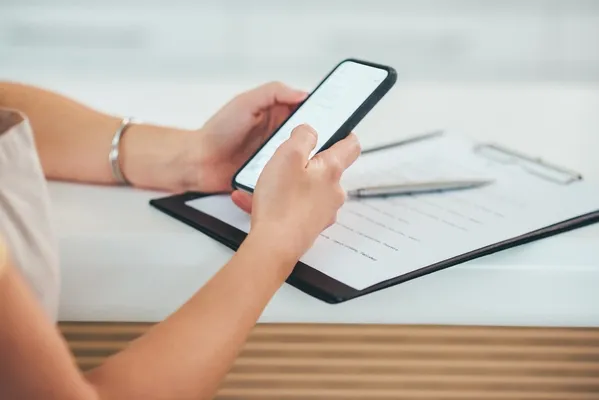 Person mit Handy und Vertrag