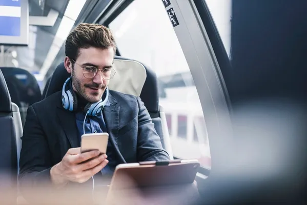 Mann nützt mobiles Internet im Zug Mann nützt mobiles Internet im Zug
