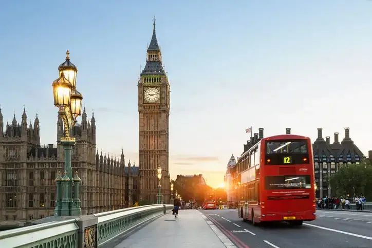 Doppeldeckerbus fährt auf der Towerbridge Richtung Big Ben