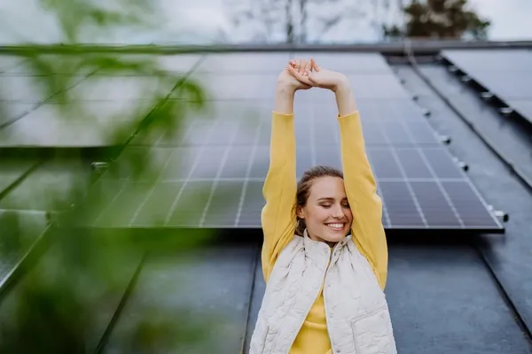Frau vor Dach voller Solarmodule