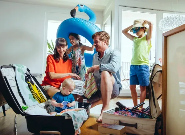 Familie packt gemeinsam Koffer für den Urlaub.
