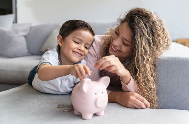 Mutter und Sohn füttern Sparschwein